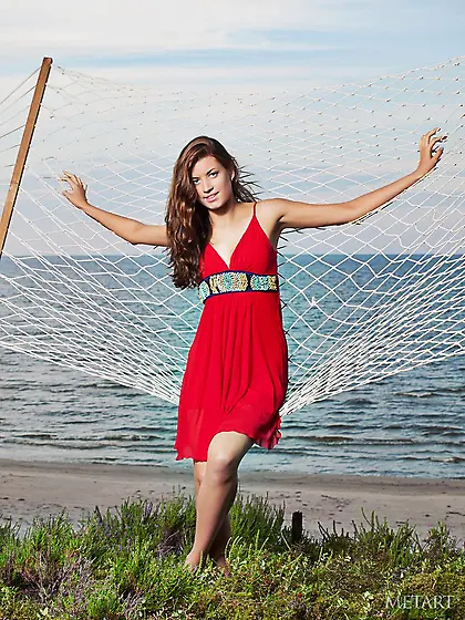 Dark-haired goddess takes off her red dress to relax in a hammoc