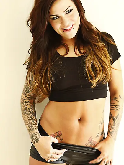 Tattooed brunette Karmen Karma is looking at man when sucking an