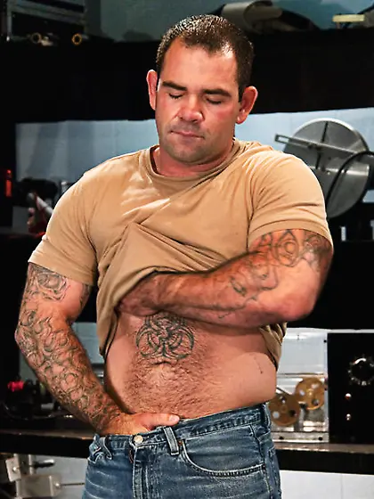 Muscled tattooed dude moans