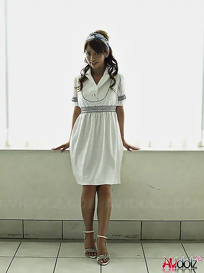 Modest Japanese sweetie dressed in white dress that accentuates