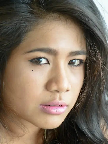 Brunette babe Rita Morey sits on the bed and squeezes her juicy