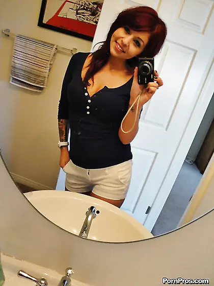 Tattooed skinny redhead takes pink panties off to demonstrate ti