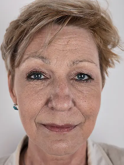 Mature porn model with tattooed shoulder advertises natural twin