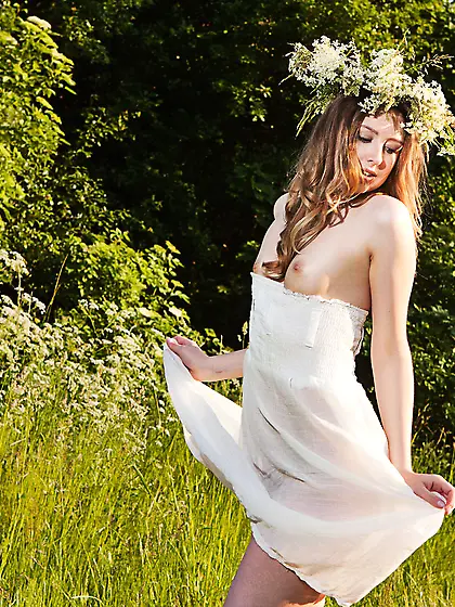 Redheaded forest nympho shows her curvy backside and ample breas