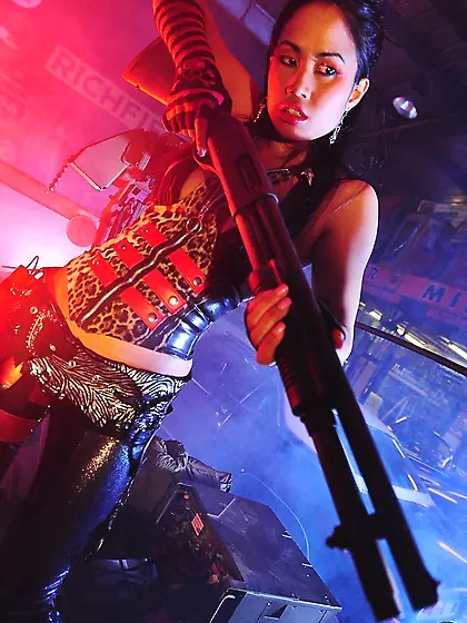 Asian fetish babe Asia McKenZie in black boots poses with shotgu