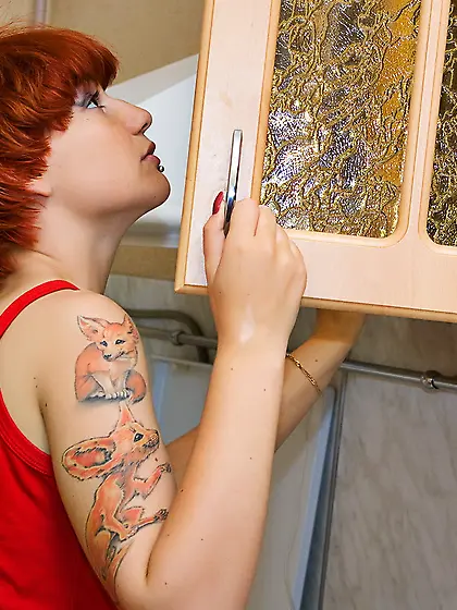 Cute teen gal Red Maggie takes off her clothes in the kitchen an