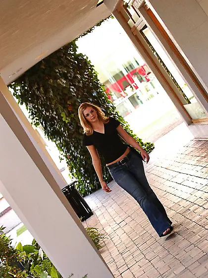 Playful blonde Brianna enjoys modeling against the car and pulls