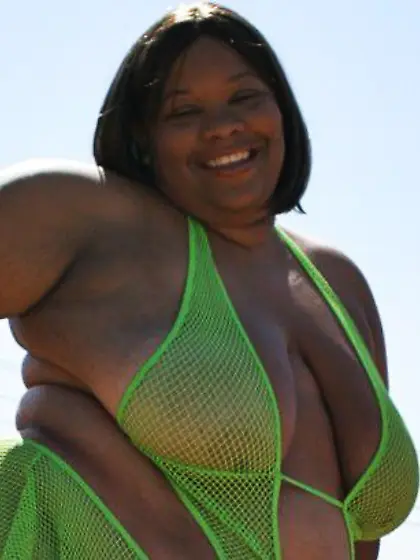 Plump dark skinned lady Chocolate Nights gives a smile before ta