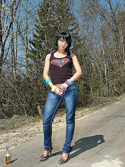 Teen brunette pissing on asphalt path outdoor