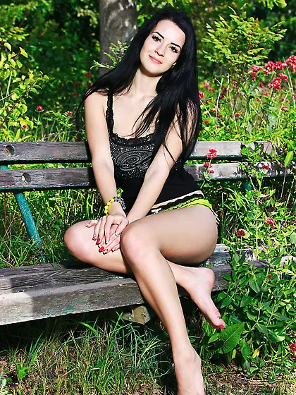 Raven-haired teen seductress takes off her green panties on a be