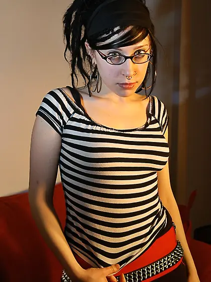 Babe with glasses and pierced nose playfully removes her clothes