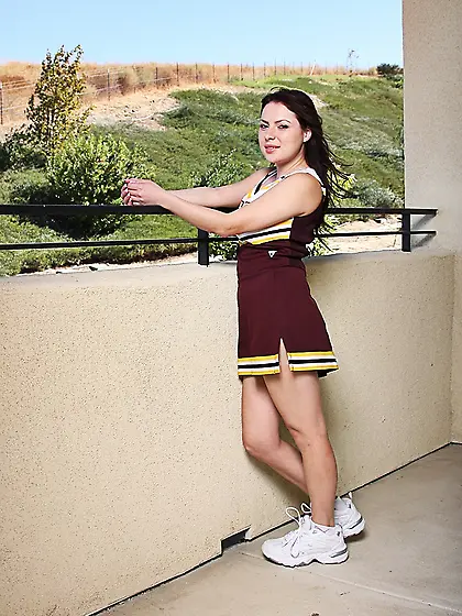 Shaved teenage cheerleader Lilly Lovely takes off her uniform an