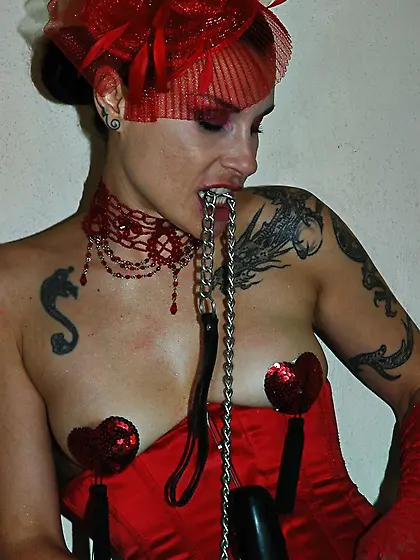 Tattooed brunette red corset