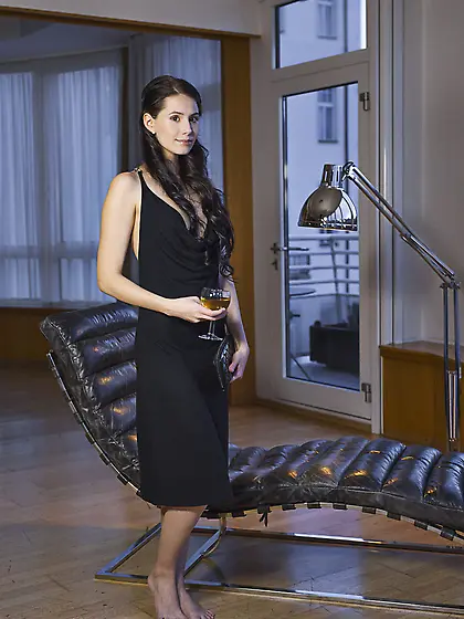 Dress-wearing brunette with weird eyes posing while half-drunk V