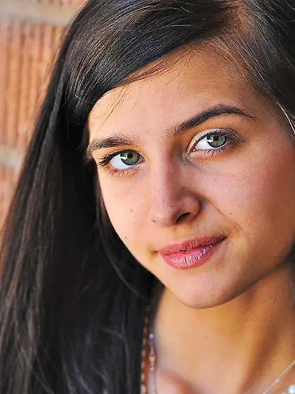 Playful dark-haired girl shows her slim body while posing in the