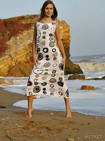 Dark-haired beauty with long legs posing on the beach and lookin